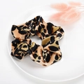 Leopard print velvet scrunchie in gold and brown tones on a minimalist white plate - Style 13 Green Coffee Leopard
