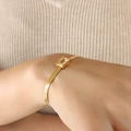 Golden herringbone chain bracelet with a rectangle clear zircon stone on a female wrist - White Zirconia Gold Bracelet (E377)
