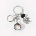 Detailed view of silver astronaut charm and planet pendant on a metal keychain - Blue Red Planet-8