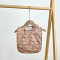 Waterproof baby bib with brown floral print and food catcher pocket on a wooden hanger - Insect Paradise