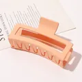 Close-up of a large matte peach-colored rectangular hair claw clip on a stylish magazine - 13cm Rectangular - Matte Ivory