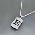 Gros plan détaillé d'un collier en acier inoxydable argenté avec pendentif lettre E évidé - Lettre E / Argent