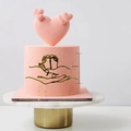 Detail view of 6.5cm gold baby shower cake topper with parent and child hand-foot line art - Hands Holding Feet Style 2 / Gold