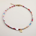 Detail of colorful beaded necklace with golden letter Q pendant and white heart bead - Letter Q