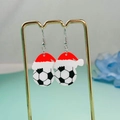 Weihnachtsfußball-Ohrringe mit Nikolausmützen auf einem goldenen Metall-Display - Fußball mit Weihnachtsmütze Stil
