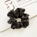 Leopard print velvet scrunchie in dark brown on an open magazine backdrop - Dark Leopard