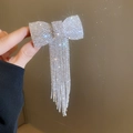 Detalle de horquilla de lazo con cristales brillantes y borlas largas de diseño elegante - Clip de resorte - Borla plateada / Plateado