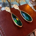 Golden teardrop earrings featuring faceted dark green gems on a brown leather display - Silver Earring Post Wrinkled Oval Emerald Drop Rhinestone Earrings