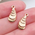 Detailed view of two gold-toned sea shell pendants with fine textured patterns for DIY jewelry - Shell Pendant 7x15mm
