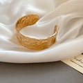 Minimalistische gouden open armband met een gehamerde geometrische textuurafwerking - Goud - Groot
