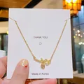 Collier élégant en titane doré avec pierre rose en forme de cœur et pendentif couronne - Cœur avec Noeud Doré