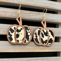 Detailansicht der Kürbis-Ohrringe mit Kuhmuster-Inlay und goldenen Haken für Halloween - Schwarz Weiß Kuh