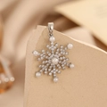 Detailed macro view of silver snowflake pendant featuring white pearls and zircon stones - Silver Snowflake Artificial Pearl