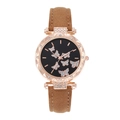 Detailed shot of a rose gold watch with crystal butterflies and a brown suede strap - Brown