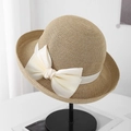 Detailed view of straw sun hat with elegant oversized cream bow and textured weaving - Khaki