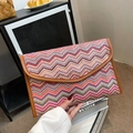 Handheld envelope straw clutch featuring colorful wave patterns and brown leather trim - Wave Pink