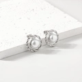 Eleganti orecchini a perno ritorti in acciaio argento con perle bianche su marmo - Color Acciaio