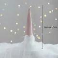 Gnomo di Natale rosa con barba bianca e sfondo bokeh LED soffuso, altezza 25 cm - Gnomo Seduto Rosa 25cm