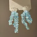 Macro detail of long beaded tassel earrings with light blue stones on a white card - 19# Silver Needle - Light Blue
