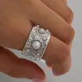 Wide silver stainless steel ring with embossed texture and multiple pearls on model hand - Wide Hammered Pearl Style (PB751)