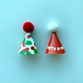 Close-up of mini green and red Christmas hat cake toppers with Merry X-mas text detail - Mini Christmas Hat Cake Decoration