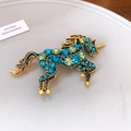 Dettaglio macro della spilla unicorno vintage con strass colorati e incisione dorata - Unicorno in Strass