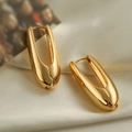 Grandi orecchini a cerchio dorati a forma di U su un elegante tessuto di raso crema - Oro