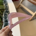 Close-up of a 10cm geometric triangle hair claw clip in translucent pink acrylic - Jelly Pink