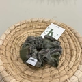 Dettaglio di un elastico per capelli scozzese verde scuro con etichetta sul cesto - Elastico a Quadri Verde Scuro e Grigio