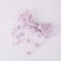 Close-up of a lavender mesh bow hair clip with detailed white daisy embroidery - Purple