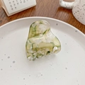 Green and creamy white marbled acetate hair claw clip on a white ceramic plate - Tea Green