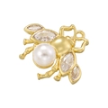 Macro shot of gold bee pendant with inlaid pearl and sparkling marquise crystals - Pendant / Gold