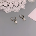 Close-up of elegant silver stainless steel hoop earrings with natural pearl pendants - Silver Pearl Style