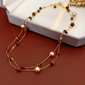 Vue détaillée du collier double rang avec pierres oeil de tigre et perles sur velours - Or Marron (Collier-Or-Marron)