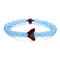 Macro detail of beaded bracelet with light blue beads and a brown goldstone butterfly - Blue Chalcedony + Goldstone Butterfly