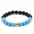 Macro shot of 8mm natural malachite and black lava stone beads with a golden accent - Emperor Stone
