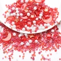 Makroaufnahme roter Stern- und Mond-DIY-Perlen mit weißen Saatperlen auf Tablett - Goldglitzer Rosa Serie