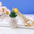 Detail eines Ananas Schlüsselanhängers mit grünen und weißen Strasssteinen - Weiß