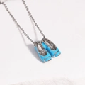 Detailed view of blue ballet shoe pendant on silver O-chain over white stone - White Gold Blue