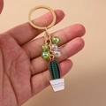 Close-up of beaded cactus keychain with golden ring and white wave pattern pot - Beaded Cactus