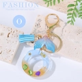 Ocean themed resin letter O keychain with blue fish tail, tassel and beach sand - Letter O