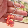 Dettaglio del portachiavi a lettera E in resina glitter rossa con anello argento - Lettera E