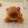 Peluche di capibara marrone disteso su una tastiera come decorazione da scrivania - 12cm / Capibara
