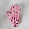 Detailed view of a pink Harajuku skeleton hand hair clip with gothic aesthetic style - Pink