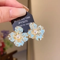 Detail of flower earring featuring blue enamel petals and a central pearl on silver needles - Gold-Blue (22# Silver Earring Post)