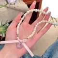 Détail du nœud en soie rose et du pendentif cœur en cristal sur collier perle - Style Cristal Coeur Rose