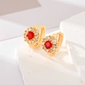 Detaillierte Nahaufnahme goldener Blumenohrringe mit rotem Stein und weißen Zirkonia-Steinen - Rot