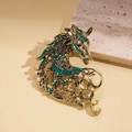 Detail of vintage gold horse brooch featuring green and purple rhinestone inlays - Green