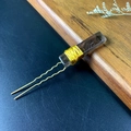 Detail of amethyst crystal hair pin with gold wire wrapping on a dark textured surface - Smoky Quartz