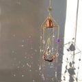 Detailed view of crystal sun catcher casting rainbow light spots on a wall - Gold Alloy + Red Jasper / Standard Size